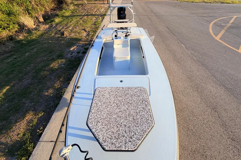 Slide: The Image of 2025 Chittum Skiffs Islamorada 21 boat on pavement, showcasing deck and seating. - 26