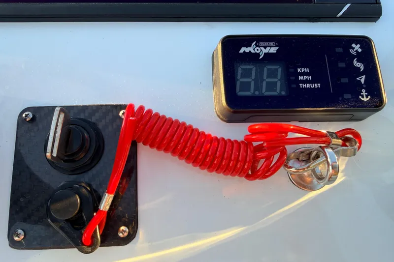 Slide: The Image of Control panel of 2025 Chittum Skiffs Islamorada 21 with digital display and red safety cord. - 49