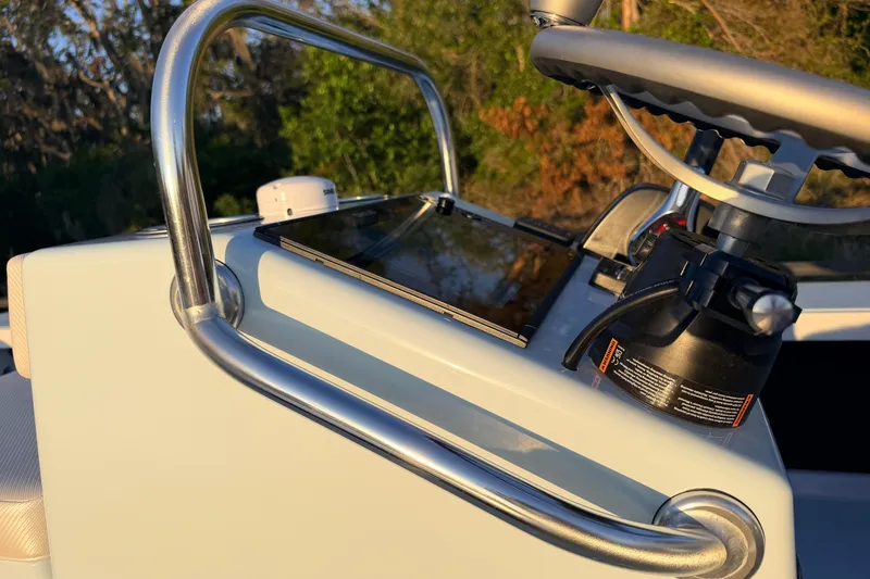 Slide: The Image of 2025 Chittum Skiffs Islamorada 21 console with steering wheel and controls in sunlight. - 52