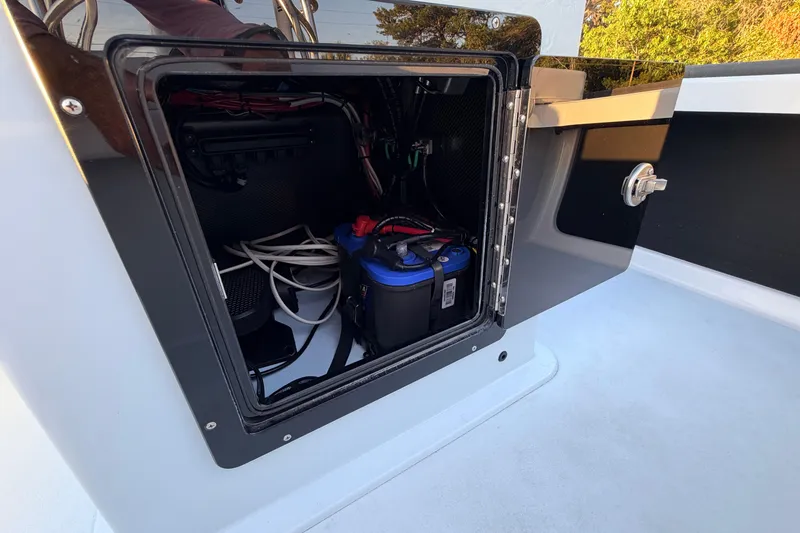 Slide: The Image of Open compartment of 2025 Chittum Skiffs Islamorada 21 showing battery and wiring. - 54