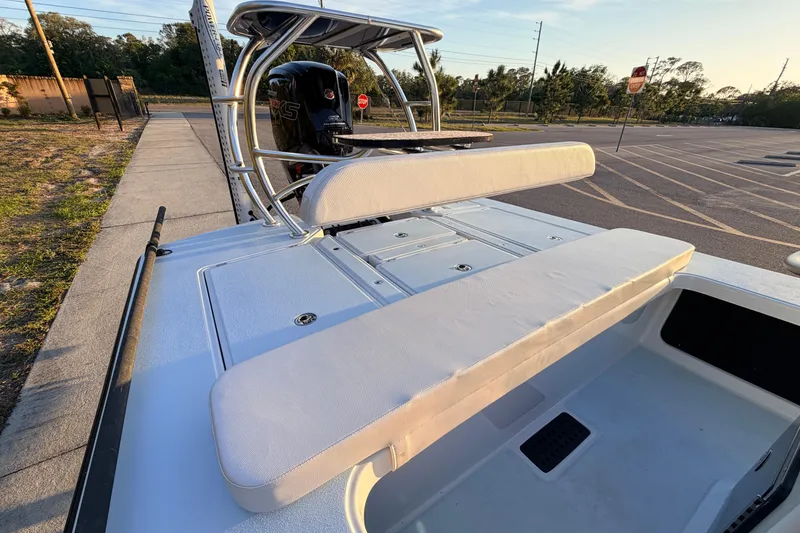 Slide: The Image of 2025 Chittum Skiffs Islamorada 21 boat with cushioned seating and sleek design in a parking area. - 58