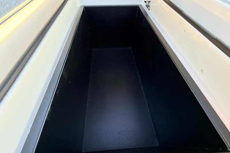 Slide: The Image of Storage compartment of 2025 Chittum Skiffs Islamorada 21 boat, featuring sleek black interior. - 63
