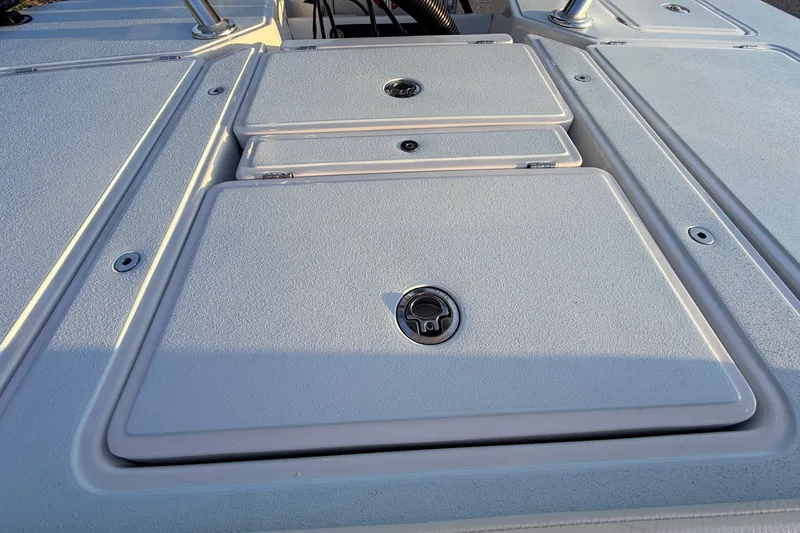 Slide: The Image of 2025 Chittum Skiffs Islamorada 21 deck with storage compartments and textured surface. - 64