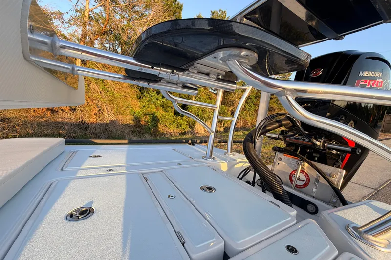 Slide: The Image of 2025 Chittum Skiffs Islamorada 21 boat deck with Mercury Pro engine, showcasing storage compartments. - 75