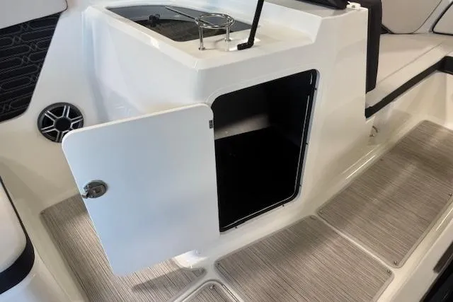 Slide: The Image of 2026 Sea Ray SPX 210 boat interior storage compartment with open door and speaker. - 13