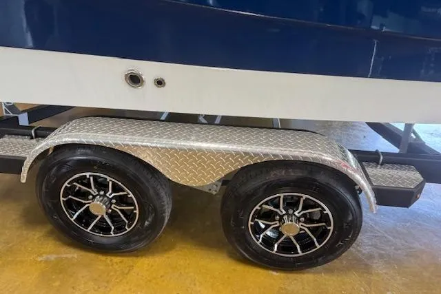 Slide: The Image of 2026 Sea Ray SPX 210 boat trailer with dual wheels and diamond plate fender. - 17