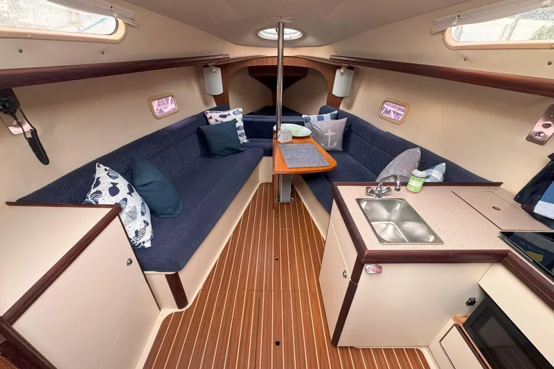 Slide: The Image of Interior of a 2007 Hunter 27 sailboat with cozy seating and compact kitchen area. - 17