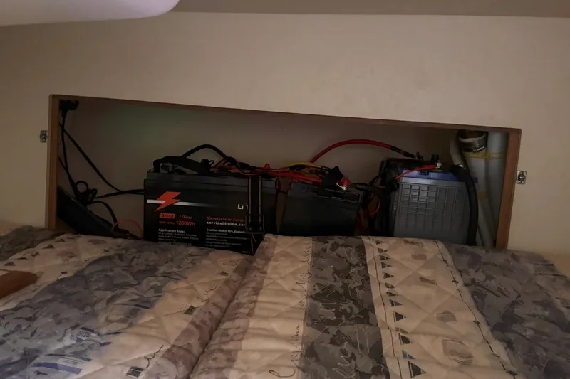 Slide: The Image of Battery compartment in a 2007 Hunter 27 sailboat, featuring multiple batteries and wiring. - 24