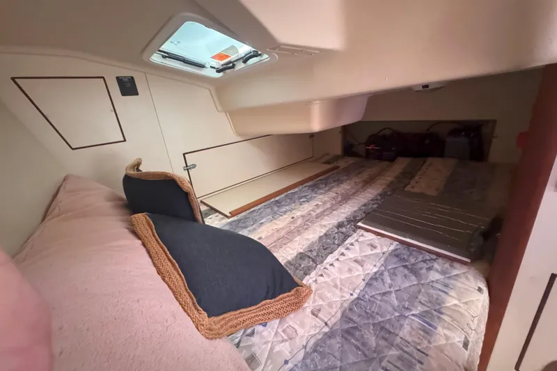 Slide: The Image of Interior cabin of a 2007 Hunter 27 sailboat with cozy bedding and pillows. - 25