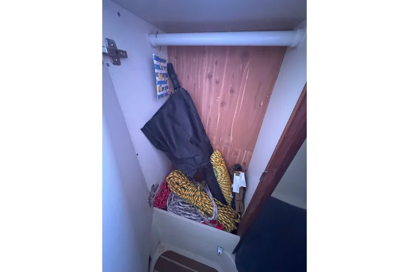 Slide: The Image of Storage compartment in a 2007 Hunter 27 sailboat with ropes and an umbrella. - 26