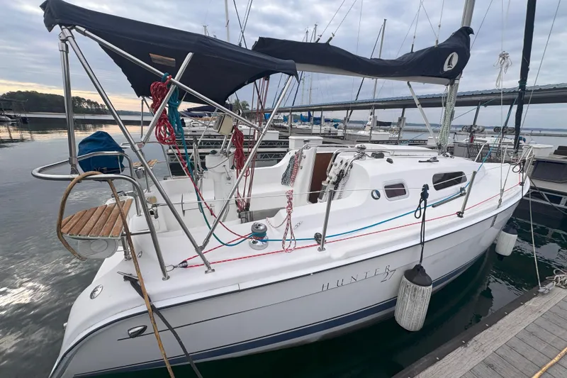 Slide: The Image of 2007 Hunter 27 sailboat docked at marina, featuring sleek design and rigging. - 3