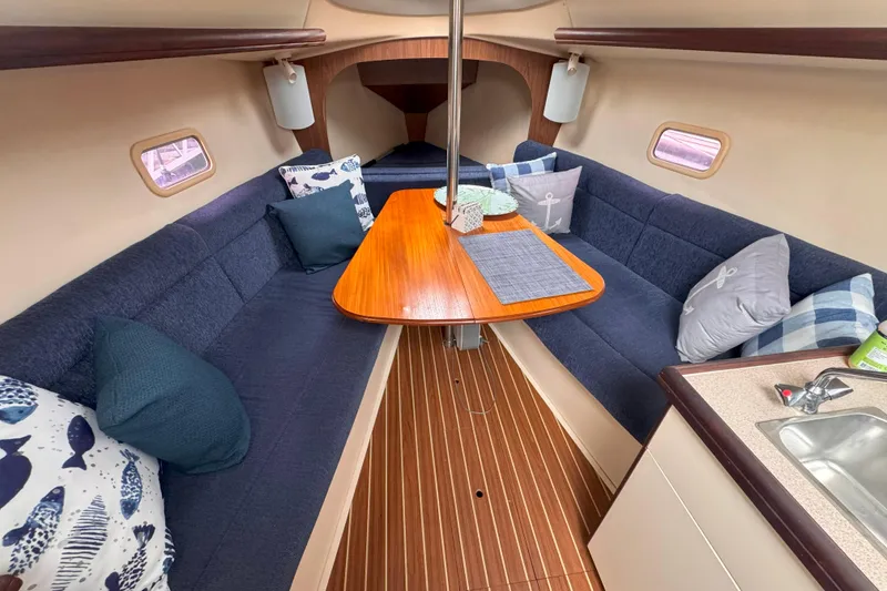 Slide: The Image of Interior of a 2007 Hunter 27 sailboat with cozy seating and wooden table. - 30