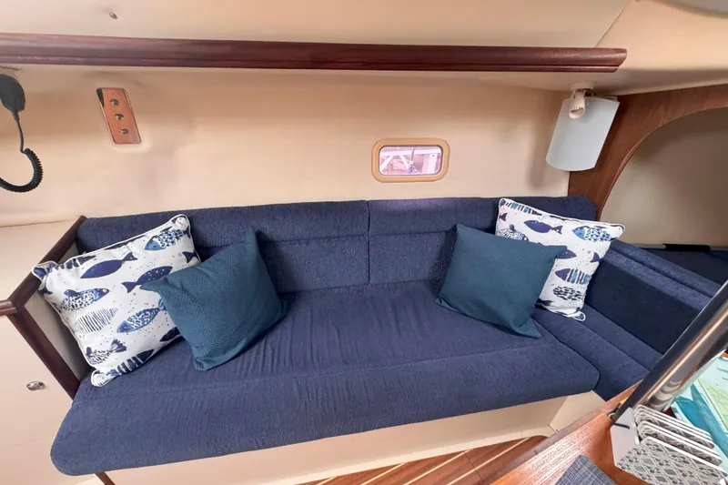 Slide: The Image of Interior of a 2007 Hunter 27 sailboat with blue cushions and decorative pillows. - 32