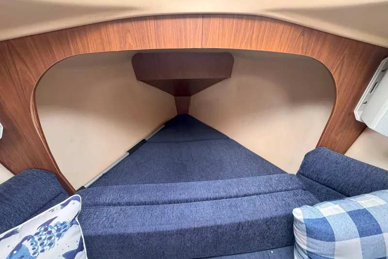 Slide: The Image of Interior cabin of a 2007 Hunter 27 sailboat with blue cushions and wooden accents. - 33