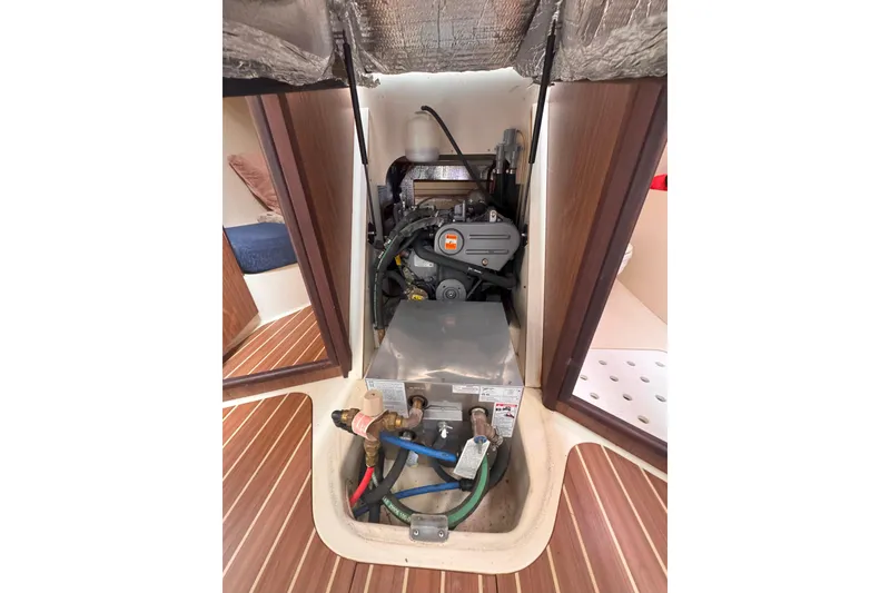 Slide: The Image of Engine compartment of a 2007 Hunter 27 sailboat, showcasing mechanical components and wiring. - 35