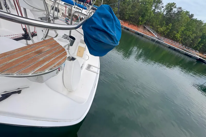 Slide: The Image of Hunter 27 sailboat from 2007 docked by calm waters and lush greenery. - 7