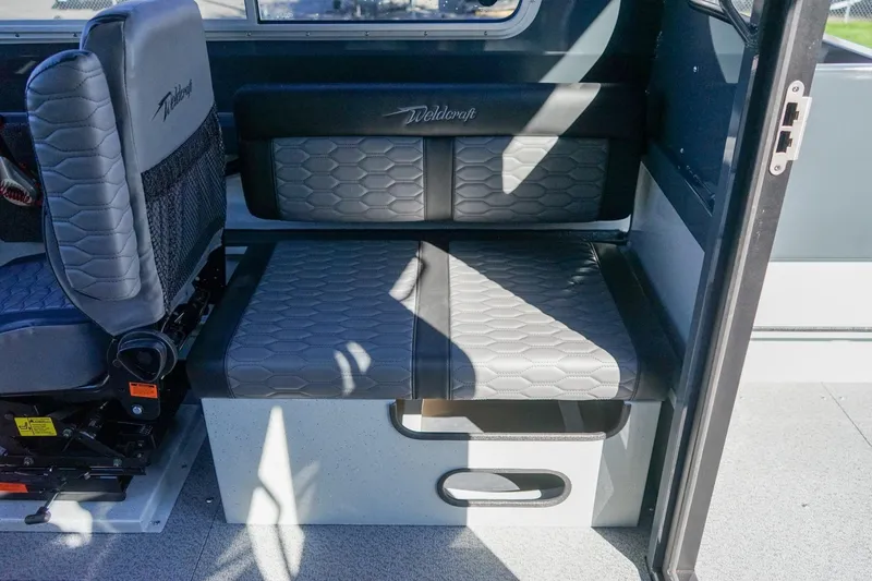 Slide: The Image of Interior seating of 2026 Weldcraft 210 Revolution boat, featuring gray cushioned seats. - 12