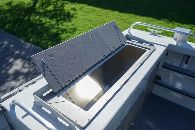 Slide: The Image of Open storage compartment on 2026 Weldcraft 210 Revolution boat, with green grass background. - 7
