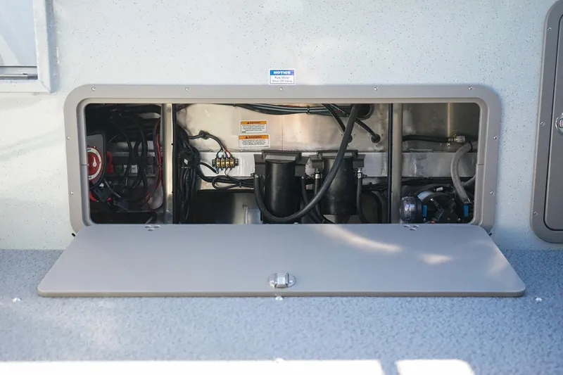 Slide: The Image of Open compartment of 2026 Weldcraft 210 Revolution boat showing internal wiring and components. - 8