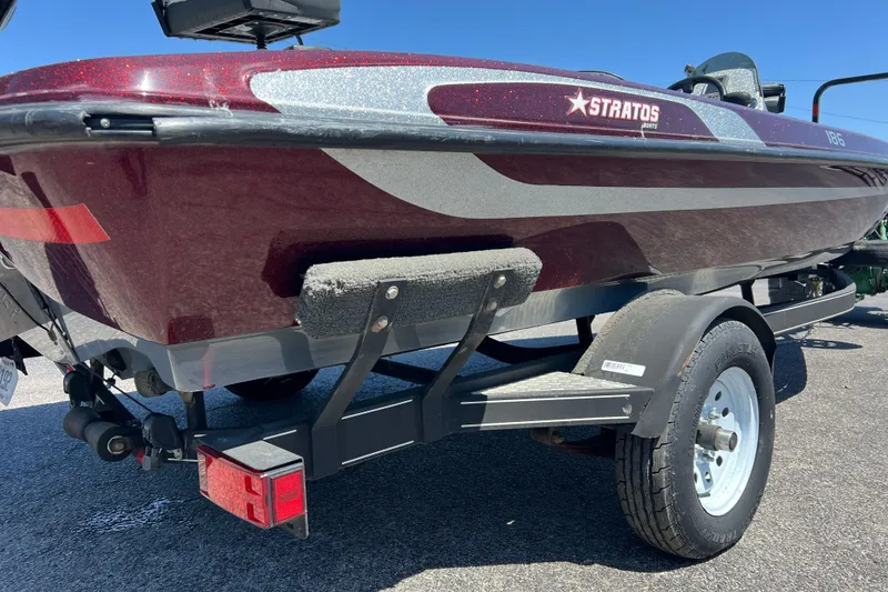 Slide: The Image of 2015 Stratos 186 VLO boat on trailer, maroon and silver design, sunny day. - 6