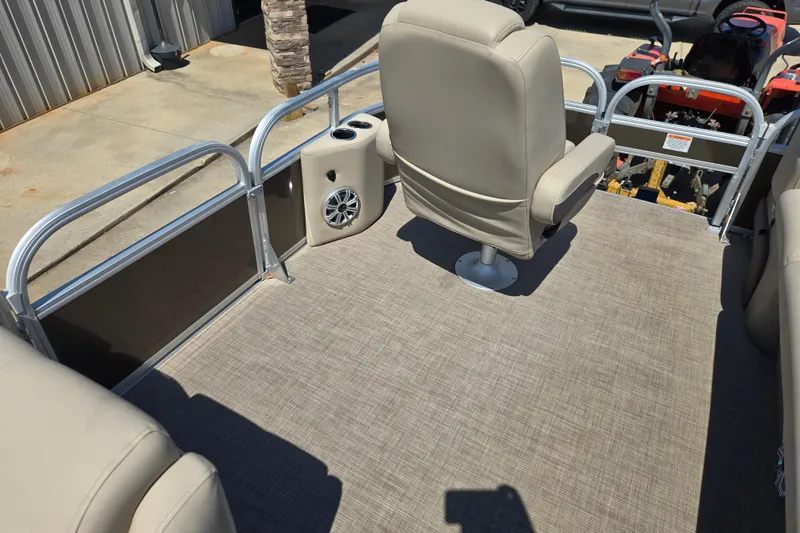 Slide: The Image of 2023 Sun Tracker SportFish 20 DLX pontoon boat interior with beige seating and speaker. - 16
