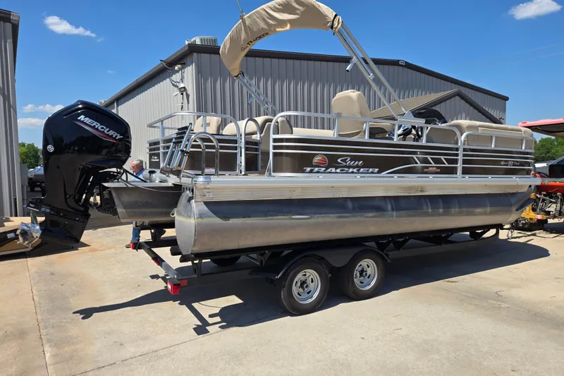 Slide: The Image of 2023 Sun Tracker SportFish 20 DLX pontoon boat with Mercury engine on trailer. - 2