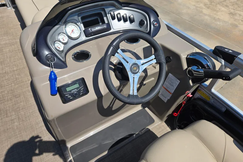 Slide: The Image of 2023 Sun Tracker SportFish 20 DLX boat dashboard with steering wheel and controls. - 20