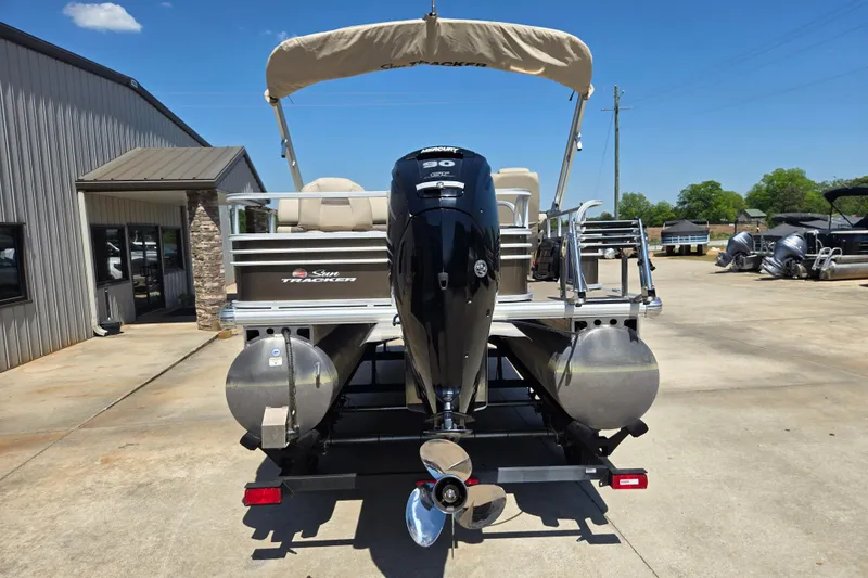 Slide: The Image of 2023 Sun Tracker SportFish 20 DLX pontoon boat with outboard motor, parked outdoors. - 7