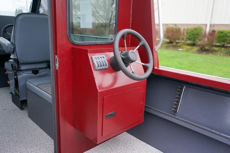 Slide: The Image of 2026 Alumaweld Intruder Outboard 22 interior with red helm and steering wheel. - 11