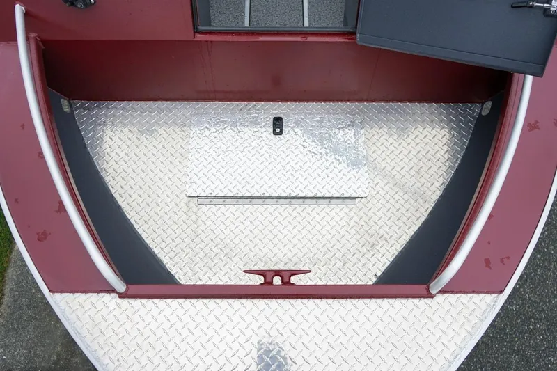 Slide: The Image of 2026 Alumaweld Intruder Outboard 22 boat deck with diamond plate flooring and open storage compartment. - 22