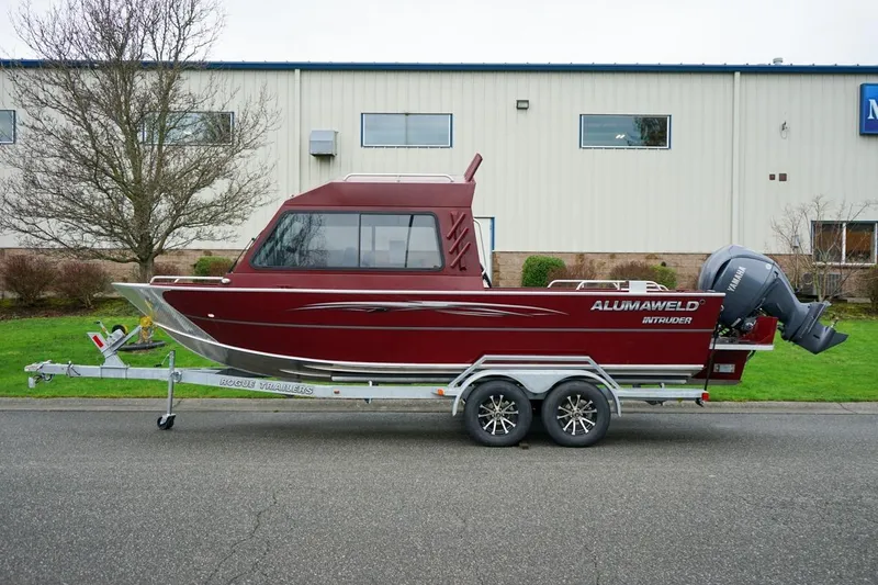 Slide: The Image of 2026 Alumaweld Intruder Outboard 22 boat on trailer, parked outdoors. - 3