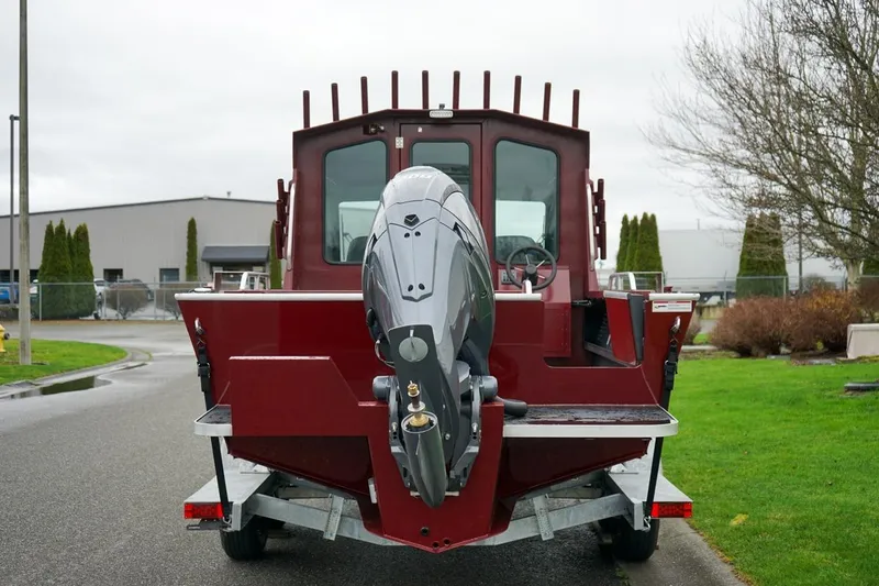 Slide: The Image of 2026 Alumaweld Intruder Outboard 22 boat, rear view with outboard motor, parked outdoors. - 5