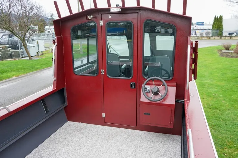 Slide: The Image of 2026 Alumaweld Intruder Outboard 22 boat interior with red cabin and steering wheel. - 6