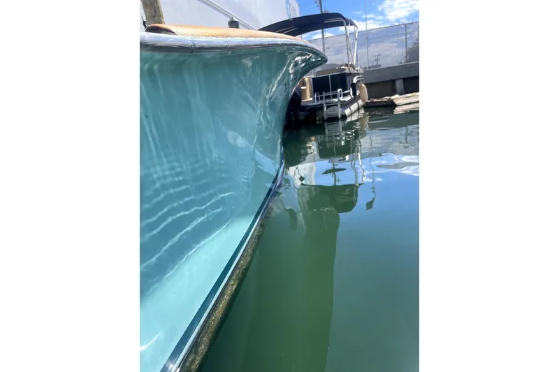 Slide: The Image of 1977 Scarborough 27 CC boat helm with steering wheel, docked near yachts. - 11