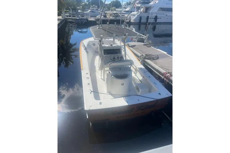 Slide: The Image of 1977 Scarborough 27 CC boat interior with white seating, docked near palm trees. - 17