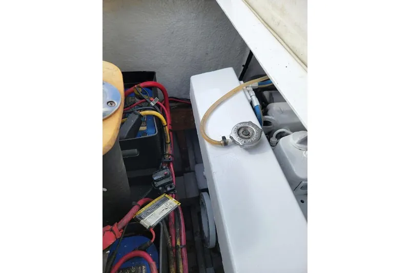 Slide: The Image of 1977 Scarborough 27 CC boat docked, featuring a clean white deck and seating area. - 19