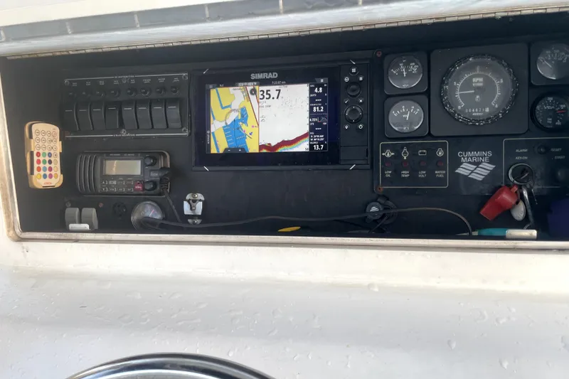 Slide: The Image of 1977 Scarborough 27 CC boat interior with white seating and dockside view. - 8