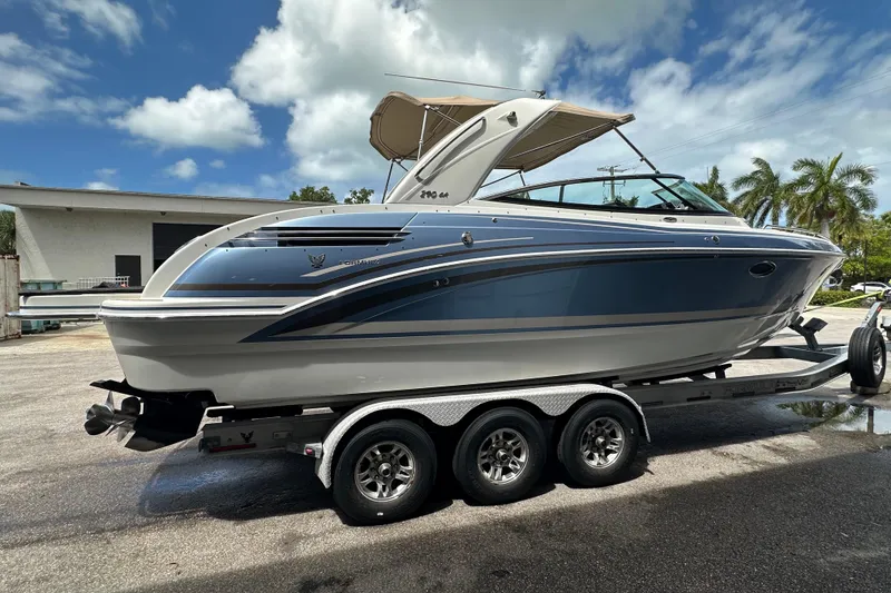 Slide: The Image of 2018 Formula 290 Bowrider boat on trailer, parked outdoors under a sunny sky. - 2