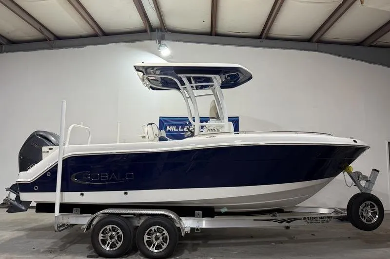 The Image of 2026 Robalo R222 Explorer boat on trailer in indoor showroom. - 0
