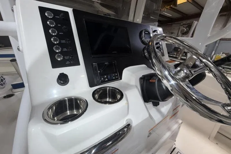 Slide: The Image of 2026 Robalo R222 Explorer boat dashboard with steering wheel and control panel. - 16