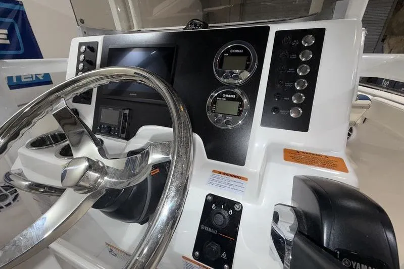 Slide: The Image of 2026 Robalo R222 Explorer boat dashboard with steering wheel and Yamaha controls. - 17