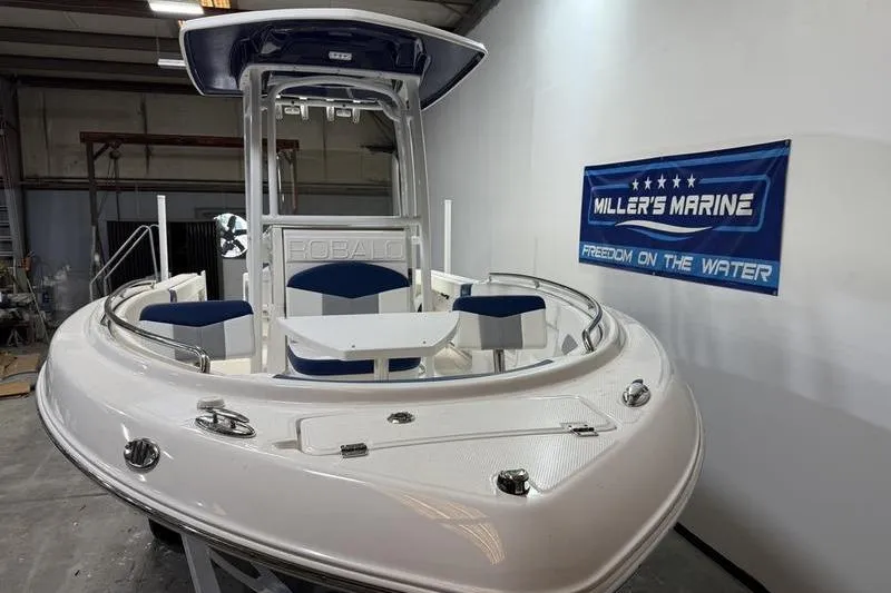 Slide: The Image of 2026 Robalo R222 Explorer boat displayed indoors at Miller's Marine showroom. - 2