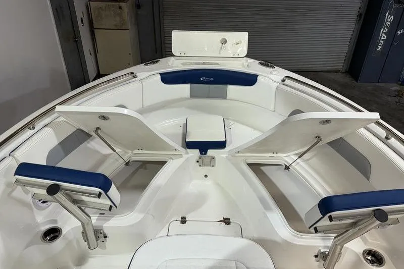 Slide: The Image of 2026 Robalo R222 Explorer boat interior with open storage compartments and blue seating. - 24