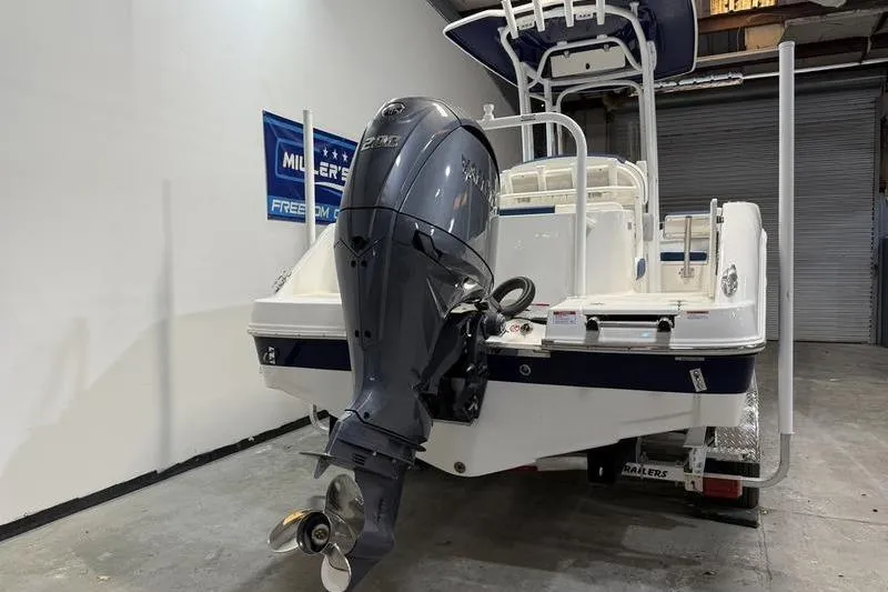 Slide: The Image of 2026 Robalo R222 Explorer boat with powerful outboard motor in a showroom. - 4