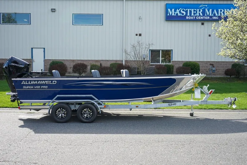 Slide: The Image of 2026 Alumaweld Super Vee Pro 21 boat on trailer outside Master Marine Boat Center. - 3