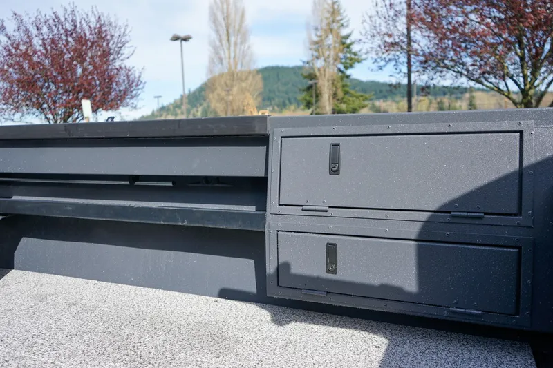 Slide: The Image of 2026 Alumaweld Super Vee Pro 21 boat storage compartments with scenic background. - 9