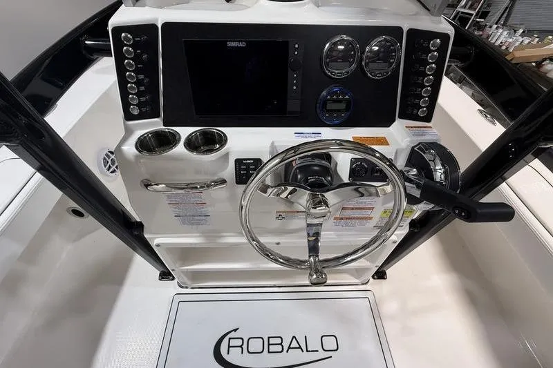 Slide: The Image of 2026 Robalo 226 Cayman boat dashboard with steering wheel and control panel. - 11