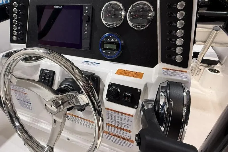 Slide: The Image of Helm of 2026 Robalo 226 Cayman featuring steering wheel, gauges, and control panel. - 12