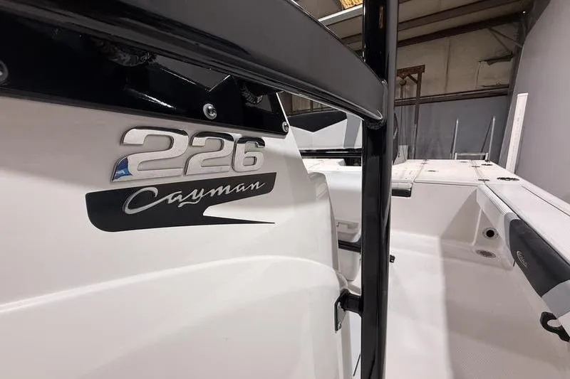 Slide: The Image of 2026 Robalo 226 Cayman boat interior with logo detail in a showroom setting. - 15