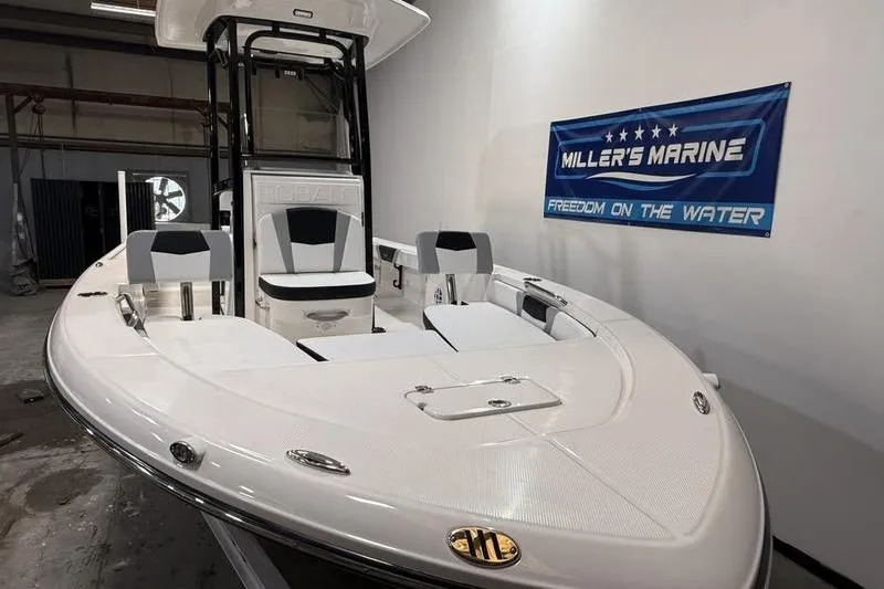 Slide: The Image of 2026 Robalo 226 Cayman boat displayed indoors at Miller's Marine showroom. - 2
